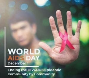 A hand with a red AIDS ribbon in focus, person blurred in background. Text World AIDS Day, December 1. Ending the HIV/AIDS Epidemic Community by Community.