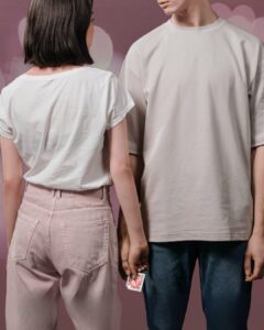 Two people standing next to each other seen from the back stan