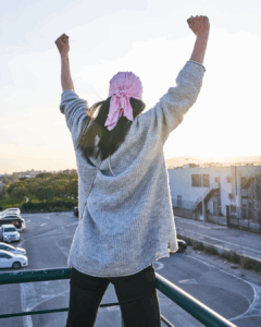 Recovery Journey - A woman with arms raised looking to the horizon
