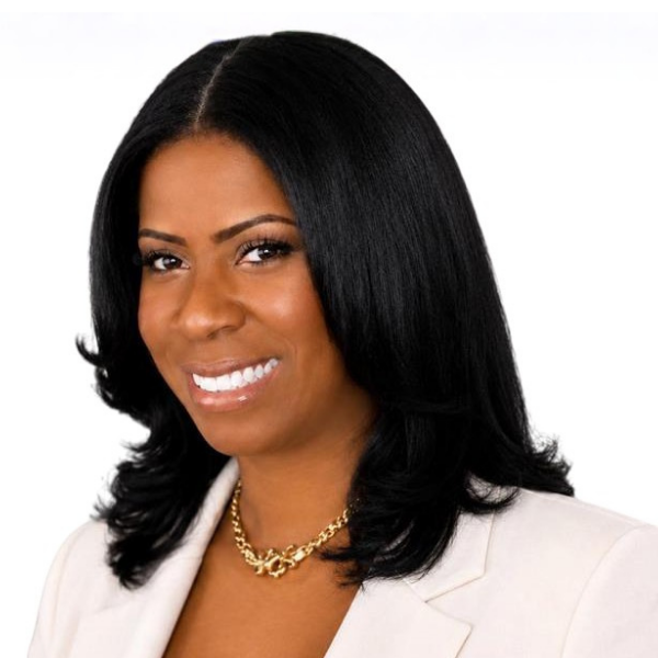 A smiling photo of Nichole Roberts with dark shoulder-length hair wearing a light blazer.